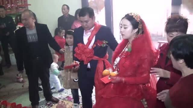福建农村结婚,正在拜堂,新郎新娘中间站了一个小女孩 