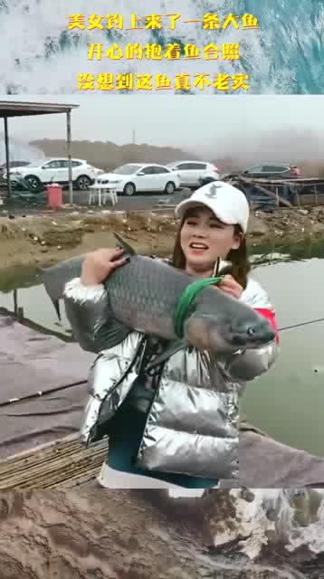 美女钓上来了一条大鱼,开心的抱着鱼合照,没想到这鱼真不老实 